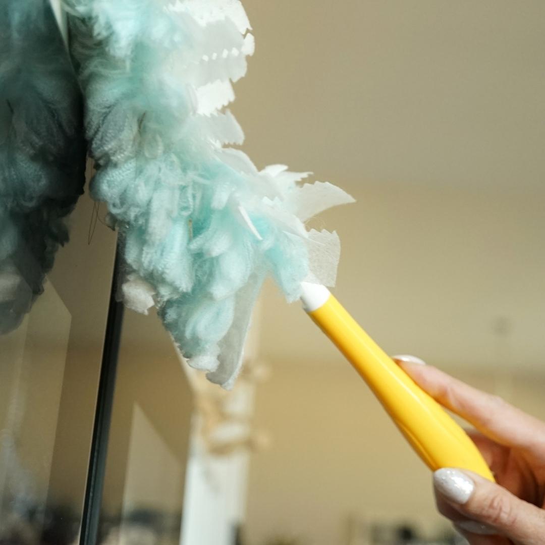 Woman dusting surface in a home