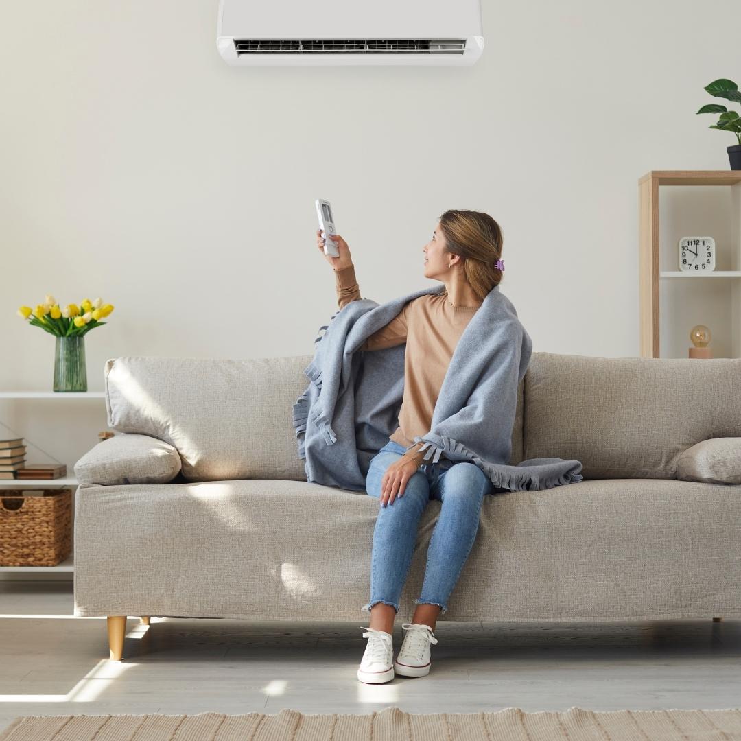 Woman adjusting hvac because she is cold